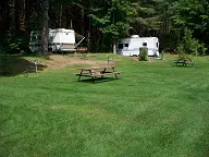 A couple of campers are parked in the grass
