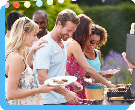 A group of people standing around a grill.